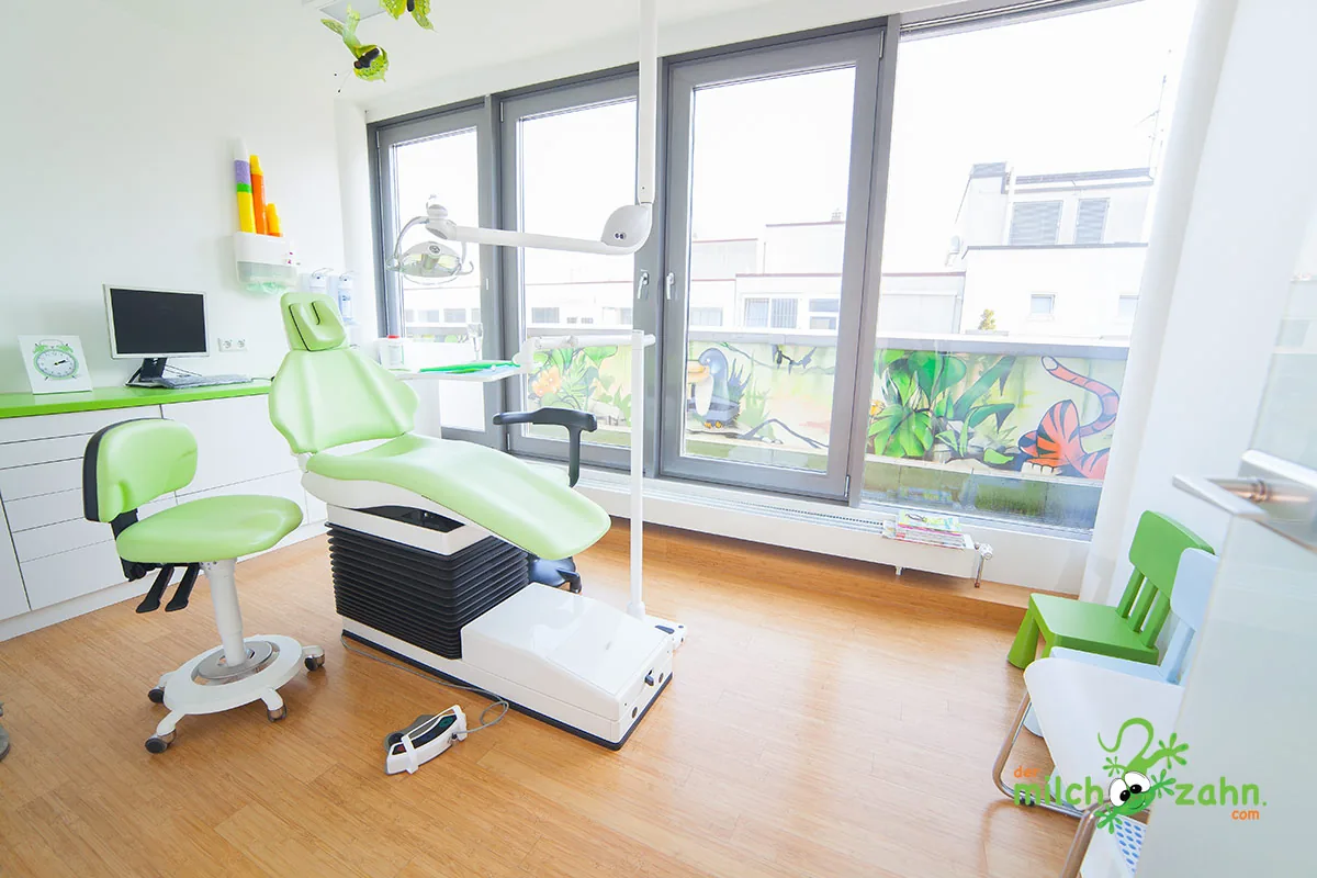 Behandlungszimmer mit grünem Stuhl und Dschungel-Graffiti mit Tukan und Schlange am Fenster